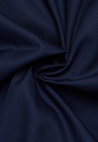 Tessuto blu navy con una superficie liscia e leggermente lucida, caratterizzato da una tessitura semplice che crea una leggera lucentezza. Aspetto stropicciato.