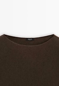 Pull en maille brun foncé avec un col arrondi montrant une étiquette noire indiquant « Massimo Dutti Made in China » au niveau de l'arrière du col.
