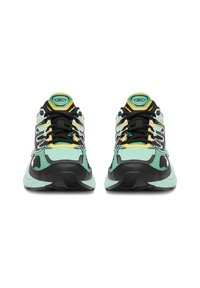 Zelené a čierne športové topánky majú sieťovaný zvršok, reflexné prvky, hrubé kontrastné podrážky a žlté šnúrky v športovom dizajne.