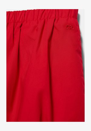 Tessuto rosso con vita elastica arricciata e piccolo logo ricamato vicino all'angolo in alto a destra.