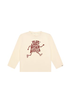 Roomkleurig shirt met lange mouwen met een rode afbeelding van lopende benen en de tekst "Play Loud! Dream Bigger" in gestileerde letters aan de voorkant.
