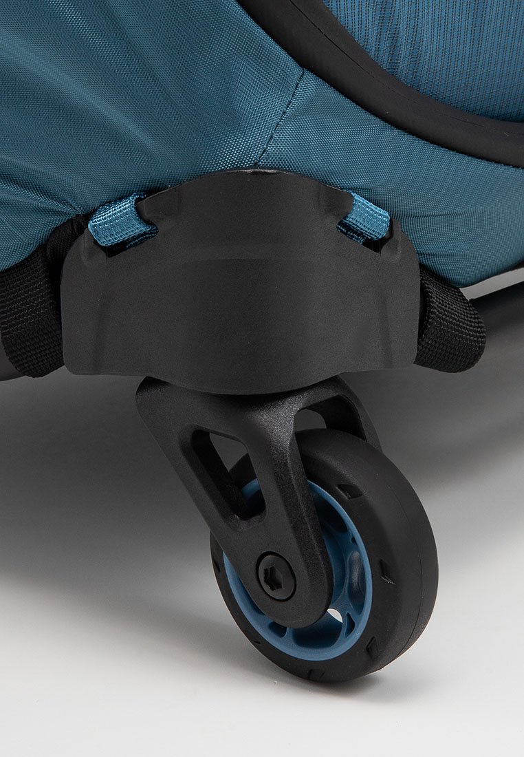 Maleta azul con ruedas en la esquina, que presenta una carcasa texturizada y oscura, una rueda negra giratoria y detalles en azul en la rueda y los acentos de tela.