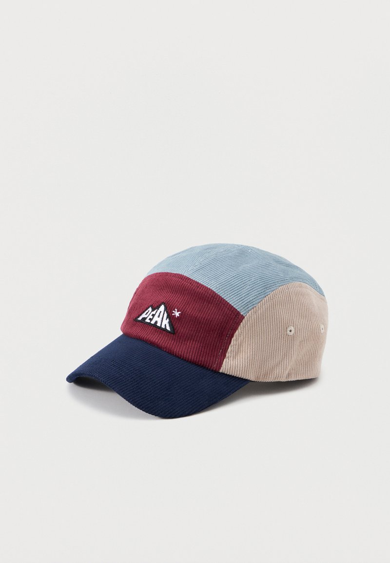 Cordmütze mit Farbblöcken in Hellblau, Bordeaux, Beige und Marineblau, mit einem Berglogo-Patch mit dem Wort "PEAK" auf der Vorderseite.