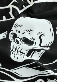 Tessuto nero con una grande grafica di teschio bianco dotata di dettagli, tra cui crepe e ombreggiature, accompagnata da un motivo con ossa incrociate.