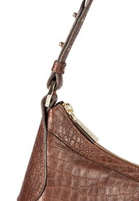 Sac à main en cuir brun avec embossage crocodile, doté d'une fermeture éclair dorée et de quincaillerie avec une finition texturée et une forme structurée.