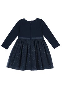 Tmavě modré šaty s dlouhým rukávem, s přiléhavým vrškem a rozšířenou tylovou sukní zdobenou malými puntíkovanými vzory. Zapínání na zip na zádech, měkká látka.