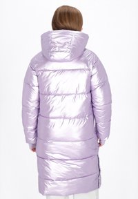 Hosszú, puffos kabát fényes lila anyagból; kapucnival, vízszintes varratokkal és oldalsó hasítékokkal a könnyebb mozgás érdekében.