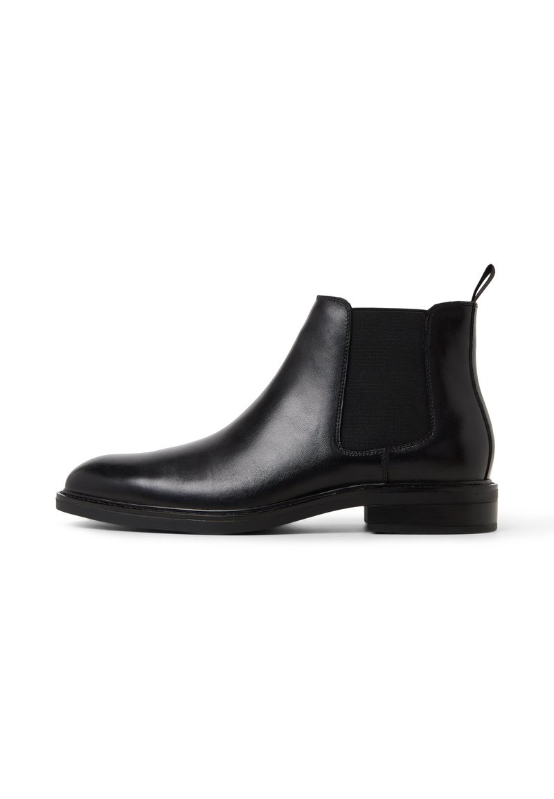 Svart läder Chelsea-boot med elastiska sidopaneler, en dragflik vid hälen och en låg staplad klack mot en vit bakgrund.