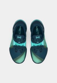 Sportsko med mørkeblå overdel med et gradientmønster, der går over til teal, tekstureret mesh-materiale og snørebåndsdesign.
