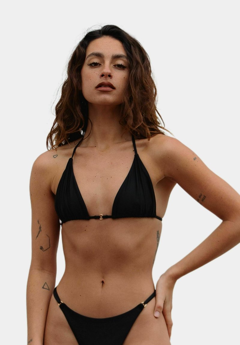 Czarny komplet bikini z trójkątnym topem na cienkich ramiączkach i złotym detalem, w komplecie z dopasowanymi, niskimi majtkami.