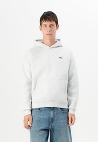 Hoodie cinza claro feito de mistura de algodão. Apresenta um bolso canguru e capuz ajustável com cordão. Pequeno logótipo preto "OBEY" no peito.
