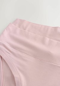 Tessuto rosa chiaro, texture liscia, presenta una cintura ampia con cuciture sottili e un design aderente, adatto per l'abbigliamento attivo o per il tempo libero.