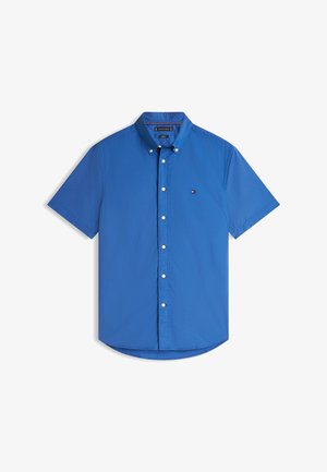 Koszula z krótkim rękawem zapinana na guziki, wykonana z jasnoniebieskiej bawełny. Posiada szpiczasty kołnierzyk, białe guziki oraz małe logo na piersi.