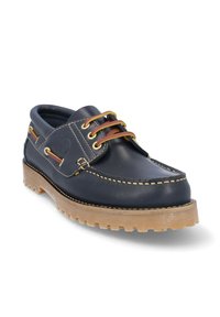 Zapato de barco de cuero azul oscuro con puntera redonda, costuras amarillas, cordones marrones y una suela de goma resistente. Presenta ojales metálicos y acentos laterales.