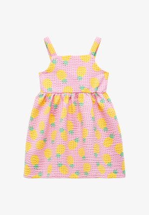 Robe rose avec un motif texturé en damier, comportant des ananas jaunes et des feuilles vertes. Bretelles ajustables, jupe évasée.
