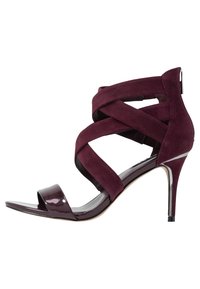 Burgundské sandály na vysokém podpatku se lesklým lakovaným páskem přes prsty, měkkým zamakovým zkříženým designem a štíhlým metalickým jehlovým podpatkem.