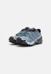 Baskets de trail running bleues avec tige en mesh et synthétique, semelle extérieure en caoutchouc noir et accents blancs et gris prononcés. Équipées d'un système de laçage rapide.