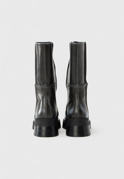 Μαύρα δερμάτινα μποτάκια μέχρι τον αστράγαλο με κομψό σχεδιασμό. Διαθέτουν λεία επιφάνεια, διακριτικό ραφές και χοντρή μαύρη σόλα.