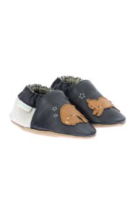 Scarpine per neonati in pelle nera con parti superiori elasticizzate, decorate con un design di orsetto marrone e piccoli motivi a stella bianchi sulla superficie. Materiale della suola morbido.