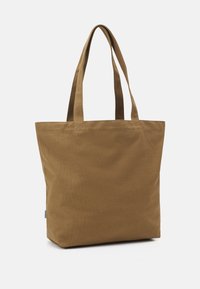 Ruskea kangasverkkokassi, jossa on kaksi tukevaa kahvaa, suorakaiteen muotoinen ja pehmeä pinta. Ei näkyviä sulkimia tai koristeita.