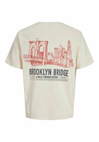 Beige színű póló, piros vázlat a Brooklyn hídról és a város látképéről, a hátsó részen a "Brooklyn Bridge 1990 - A Walk Through History" felirattal.