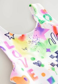 Bikini aus mehreren Farben mit weißem Hintergrund und lebhaften Mustern, darunter Sterne, Herzen und das Wort "LIEBE" in fettem Pink.