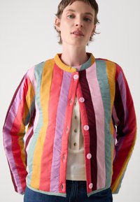 Bunt gemusterte Jacke aus Baumwollmischung, mit vertikalen Streifen in verschiedenen Schattierungen von Pink, Rot, Gelb und Grün, rosa Knöpfen und einem runden Kragen.