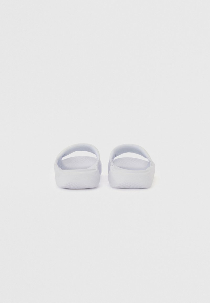 Sandalias de goma en gris claro con forma redondeada, parte trasera abierta y suela texturizada. Diseño minimalista sin herrajes ni patrones visibles.