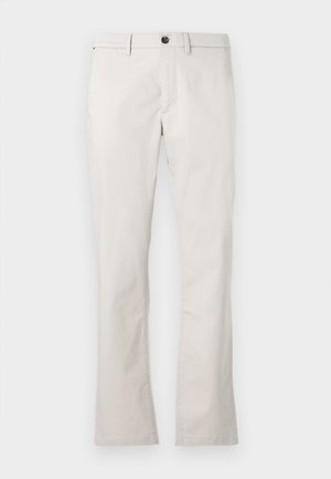 Calças de algodão em bege claro com corte reto, fecho por botão e bolsos laterais. Textura suave, sem padrões ou detalhes visíveis.