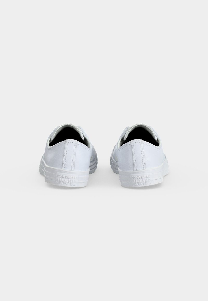 Paar weiße Converse All Star Low-Top-Sneakers, von hinten auf hellem, einfarbigem Hintergrund gezeigt.
