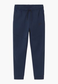 Mörkblå Nike-mjukisbyxor tillverkade av mjukt tyg, med ett elastiskt midjeband med snörning, sidfickor och avsmalnande ben.