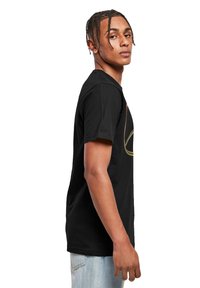 Sort bomulds T-shirt med rund hals, korte ærmer og et farverigt grafisk design på forsiden. Løs pasform, glat tekstur.