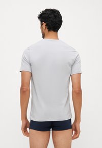 Lys grå kortermet t-skjorte med rund hals, laget av mykt stoff, med ensfarget design og rett nederkant.