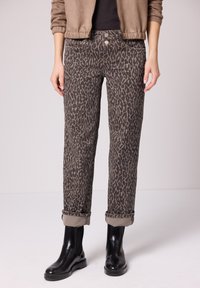 Leopardikuvioiset farkut ruskean ja mustan värimaailmassa, joissa on suora leikkaus, käännetty lahje ja kaksi etutaskua.