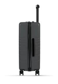 Grau Hartschalenkoffer mit gerippter Textur, schwarzem Reißverschluss und Griff, ausziehbarem Trolley und vier Rädern für einfache Mobilität.