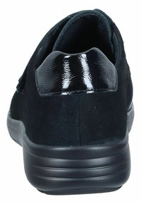 Black athletic shoe with a matte suede upper and glossy patent leather accents at the heel. Features a curved sole with ridged detailing.