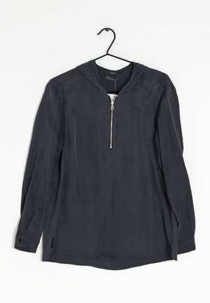 Long-sleeve dark gray hooded shirt with front zipper, hanging on a black hanger against a white background.