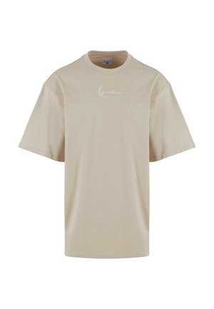 T-shirt en coton beige à coupe décontractée, à manches courtes, avec un logo blanc signature sur le devant. Texture lisse et design simple.