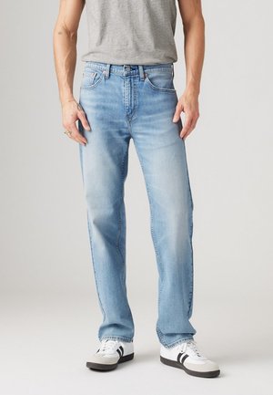 Lichtblauwe denim jeans met een rechte pasvorm, vijf zakken en een riemlus. Draag ze met een grijze T-shirt en witte schoenen met zwarte accenten.