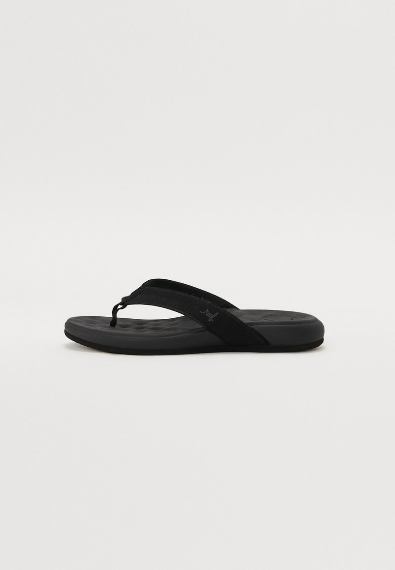 Black flip-flop sandal with textured fabric straps and cushioned sole, featuring a curved shape and subtle branding on the strap.