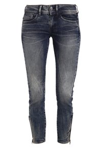 Jean skinny en denim foncé avec un effet délavé. Comprend des poches avant, une fermeture éclair aux chevilles et un design classique à cinq poches.