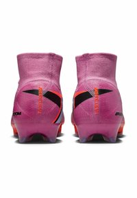 Un paio di scarpini da calcio Nike Mercurial rosa con accenti neri e arancioni, mostrati da dietro su uno sfondo bianco.