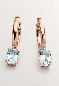 Pendientes aros de oro rosa con una gema ovalada de color azul claro y una pequeña piedra clara de acento, con una superficie pulida y suave.