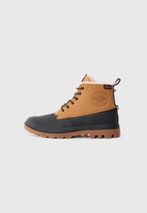 Bottes de randonnée marron et noires avec semelle en caoutchouc, col rembourré, design à lacets et logo circulaire sur le côté. Finition texturée et construction robuste.