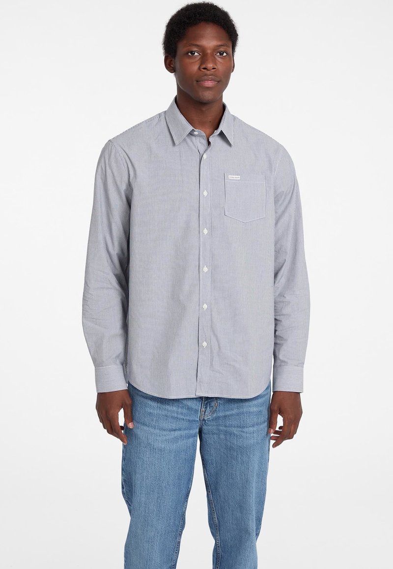 Camicia a righe leggera blu con taschino sul petto e orlo curvo. Le maniche lunghe hanno polsini con bottoni, realizzata in tessuto di cotone.