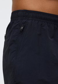 Σορτς σε ναυτικό μπλε χρώμα με ελαστική μέση, πλαϊνές τσέπες και λεπτομέρεια φερμουάρ. Κατασκευασμένα από ελαφρύ ύφασμα με λεία υφή.