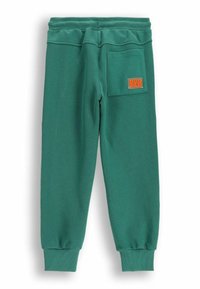 Zielone spodnie dresowe z prążkowanymi mankietami, tylną kieszenią z fakturowanym wzorem oraz pomarańczową naszywką "HUG ME".