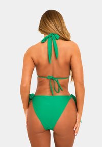 Set di bikini verde con scollo a halter e chiusura con laccetti, lacci sul retro e dettagli con laccetti ai lati delle mutande. Materiale morbido e elastico.