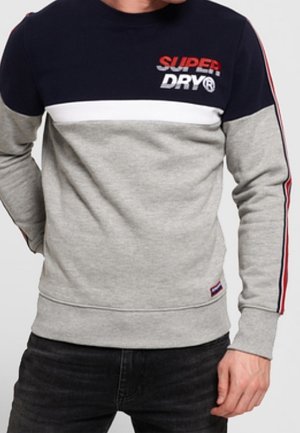 Grauer und marineblauer Pullover mit Logo, mit weißen und roten Streifen an den Ärmeln. Gerippte Bündchen und Saum, weiche Textur, Rundhalsausschnitt.