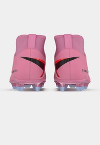 Et par rosa høyde fotball sko med røde og svarte Nike swoosh logoer, sett fra bak på en hvit bakgrunn.